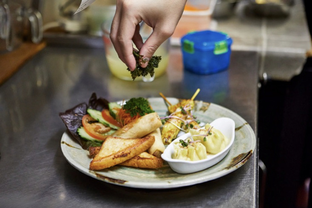 Chef plating a dish in a kitchen