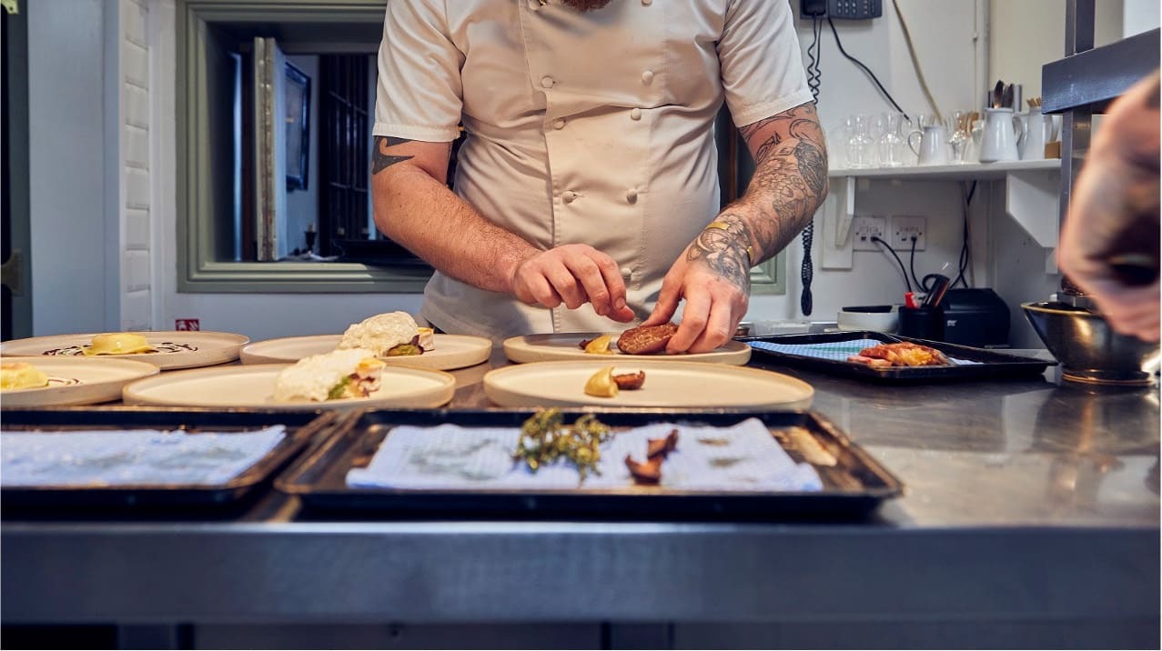 Chef plating dishes in a kitchen